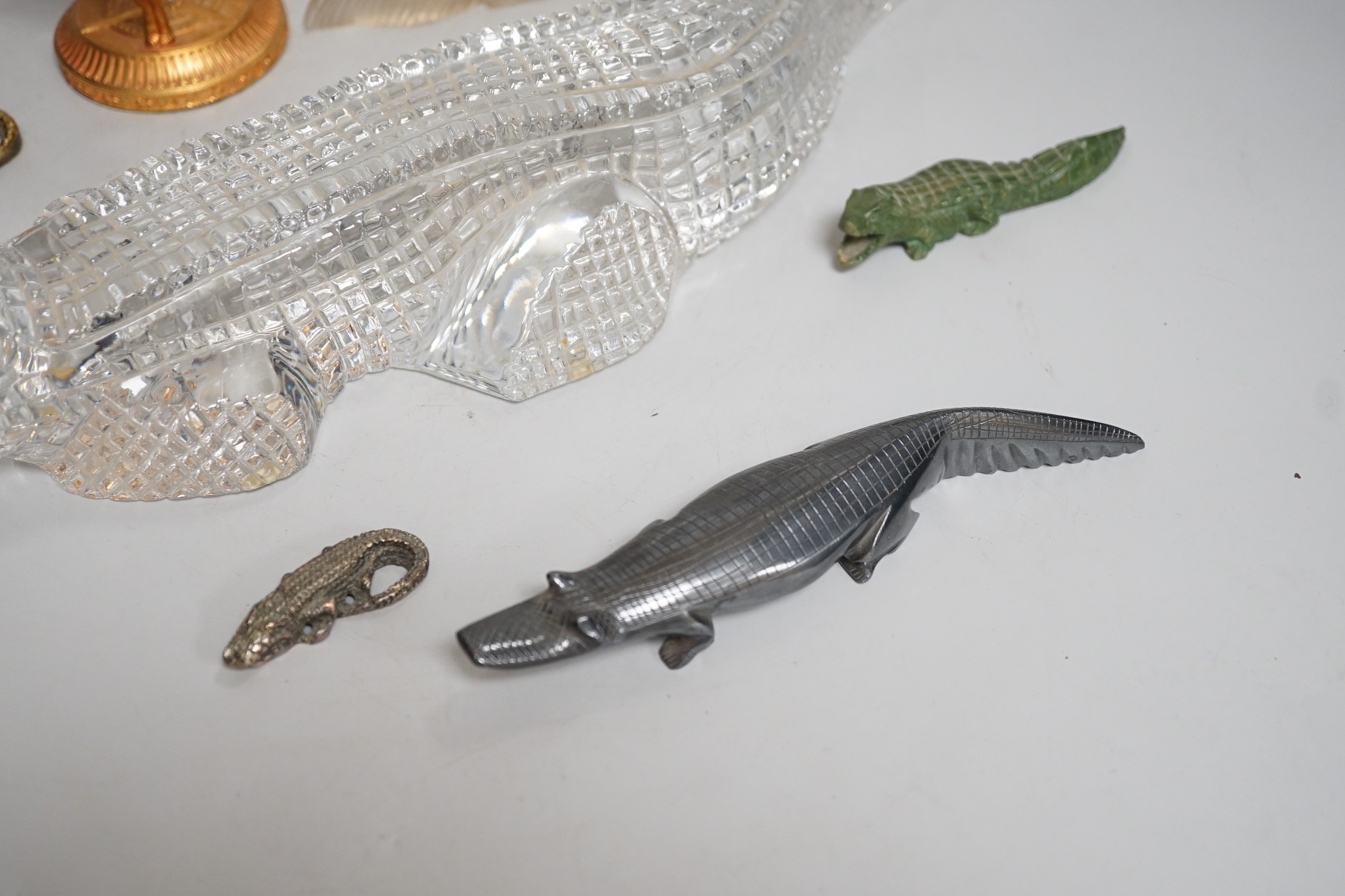 A crystal ball on gilt metal stand, 19cm tall, together with a hermatite crocodile, a jade type crocodile and four other crocodiles